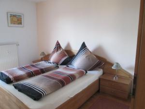 Bett mit Kissen darauf in einem Zimmer in der Unterkunft Ferienwohnung Bernhard Ehlen in Saarbrücken