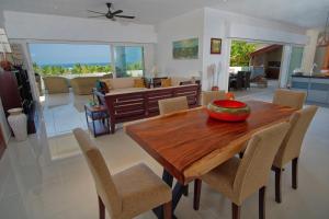 comedor y sala de estar con mesa de madera y sillas en Villa Kintana Naka, en Helville
