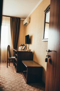 a hotel room with a desk and a window at Hotel-Restaurant Lyube Plus in Khmelnytskyi