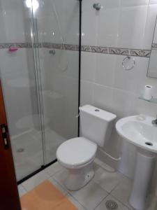 Un baño con inodoro, ducha y lavabo. en Apartamento Guilhermina - Ed Frente ao Mar, en Praia Grande 18 fotos más