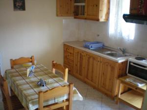 a kitchen with a table and a sink and a table and chairs at Olga Apartments in Agios Georgios