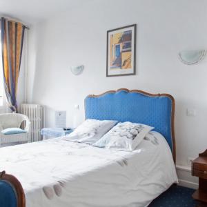 a bed with a blue headboard in a bedroom at L'Art Doize in Cassel