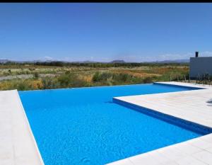una piscina de agua azul en un campo en Barrancas Suites en San Rafael