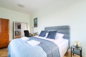 sypialnia z dużym łóżkiem z niebieskimi poduszkami w obiekcie Warsaw City Center P&O Serviced Apartments w Warszawie