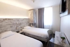 ein Hotelzimmer mit 2 Betten und einem Tisch in der Unterkunft Il Piccolo Mondo in Luxemburg (Stadt)