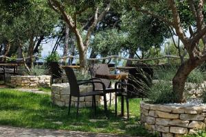dos sillas y una mesa bajo un árbol en Ark Beach Apartments en Split
