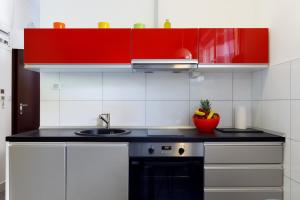a kitchen with red cabinets and a sink at Ark Beach Apartments in Split