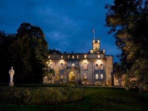 an old mansion with lights on at night at Laitse castle in Laitse