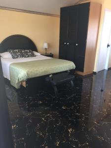 a bedroom with a bed and a black marble floor at Hostal Gipuzkoa in Viña del Mar