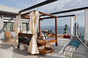 a woman laying on a bed on a balcony at Ark Beach Apartments in Split
