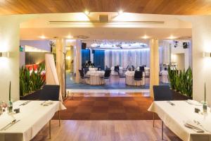 a restaurant with white tables and chairs in a room at Niebieski Art Hotel & Spa in Krakow