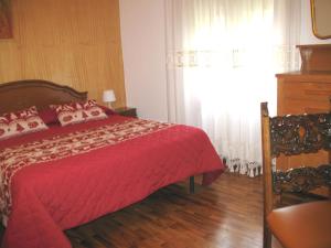 a bedroom with a red bed and a window at B&B GLI SCOIATTOLI in Rocca di Mezzo