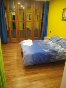 una camera da letto con letto con lenzuola blu e pavimenti in legno di Riad Navaluenga a Navaluenga