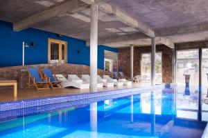 uma casa com uma piscina com cadeiras e uma mesa em Ignea Hotel em Caviahue