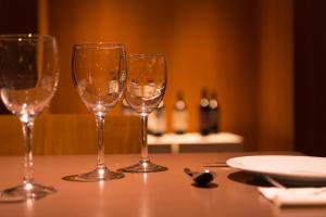 tres copas de vino sentadas sobre una mesa en Ignea Hotel en Caviahue