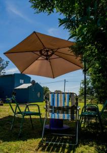 2 chaises et un parasol dans l'herbe dans l'établissement La Obra, à Tandil