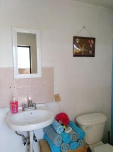 uma casa de banho com um lavatório, um WC e um espelho. em Casita Típica Cholulteca - Completa (8 prs) em Cholula