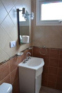 La salle de bains est pourvue d'un lavabo, d'un miroir et de toilettes. dans l'établissement Monseñor Fagnano 592 "6", à Ushuaia