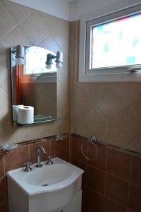 a bathroom with a sink and a mirror and a window at Monseñor Fagnano 592 "6" in Ushuaia
