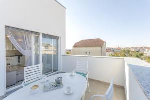 Biały balkon z białym stołem i krzesłami w obiekcie Apartments New home w mieście Vodice