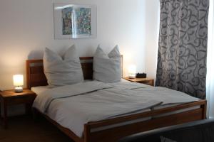 1 cama con sábanas blancas y almohadas en una habitación en Inside Apartments Speyer en Espira