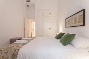 セビリアにあるGO TO SEVILLA CATHEDRALのベッドルーム(緑の枕が付く大きな白いベッド付)