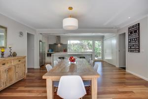 a dining room with a wooden table and white chairs at Phil's Family Holidays in Rye