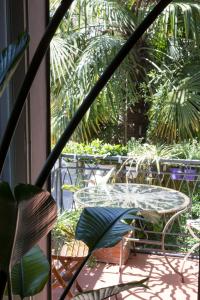 d'une terrasse avec une table, des chaises et des palmiers. dans l'établissement Leconvertite, à Trévise