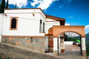 a white church with an archway next to a building at Hotel & Balneario Los Angeles in Taxco de Alarcón