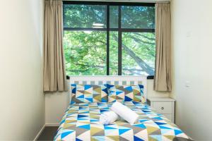 una camera da letto con un letto e una grande finestra di Hobson Lodge ad Auckland