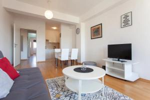 sala de estar con sofá, TV y mesa en Urban Serviced Apartments, en Skopje