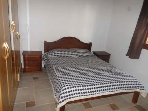 a bed with a black and white comforter in a room at El Quincho in San Luis