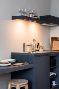 a kitchen with a blue counter with a sink at Bold Hotel München Giesing in Munich