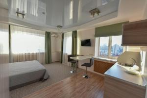 ウラジオストクにあるゴールデン ホーン ベイ ビューのベッドとデスクが備わるホテルルームです。