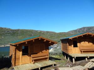 zwei Holzhütten an einem Berghang in der Unterkunft Lax-á Greenland Camp in Qassimiut