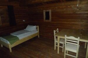 ein Zimmer mit einem Bett und einem Tisch und Stühlen in der Unterkunft Lax-á Greenland Camp in Qassimiut