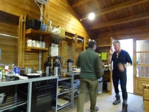 zwei Männer stehen in einer Küche und bereiten Essen vor in der Unterkunft Lax-á Greenland Camp in Qassimiut