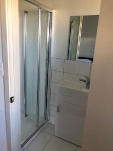 a bathroom with a shower and a sink at Waitaki Lakes Apartments - Otematata in Otematata