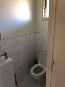 a white bathroom with a toilet and a window at Waitaki Lakes Apartments - Otematata in Otematata