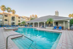 a swimming pool with blue chairs and a building at o BEAUTIFUL CONDO MINUTES FROM GORGEOUS CLEARWATER BEACHES o in Clearwater