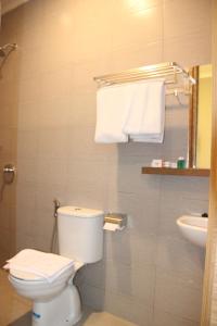 a bathroom with a toilet and a sink and towels at Front One Budget Malioboro Jogja in Yogyakarta +16 photos