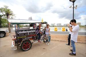 a group of people standing next to a food cart at UdonBackpackers Beds and Cafe in Udon Thani