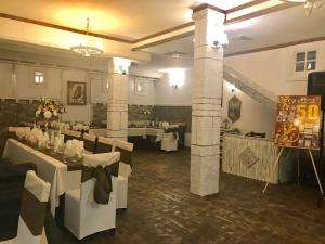 a dining room with white tables and white chairs at Hotel Verona in Byala Ruse