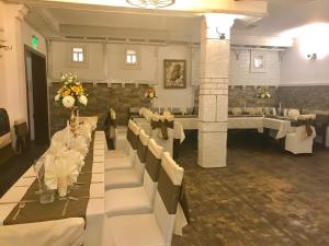a banquet hall with white tables and white chairs at Hotel Verona in Byala Ruse