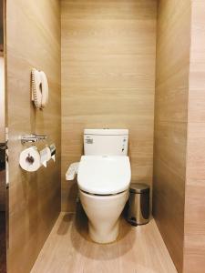a bathroom with a toilet and a toilet paper dispenser at Kaohsiung Chateau de Chine Hotel in Kaohsiung