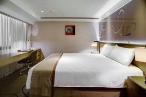高雄市にある高雄 シャトー ド シン ホテルのベッドとデスクが備わるホテルルームです。