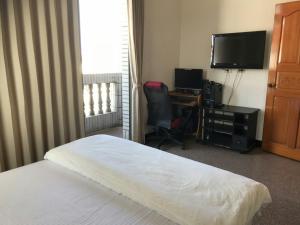 a bedroom with a bed and a desk and a television at Xiao Jinmen Homestay in Lieyu