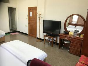 a living room with a television and a desk with a mirror at Xiao Jinmen Homestay in Lieyu