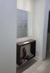 a bathroom with a vanity with a large mirror at 02 suítes em Capão da Canoa - Ed Maui in Capão da Canoa