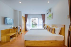 Un dormitorio con una gran cama blanca y una ventana en Rosabella Boutique Hotel en Da Nang